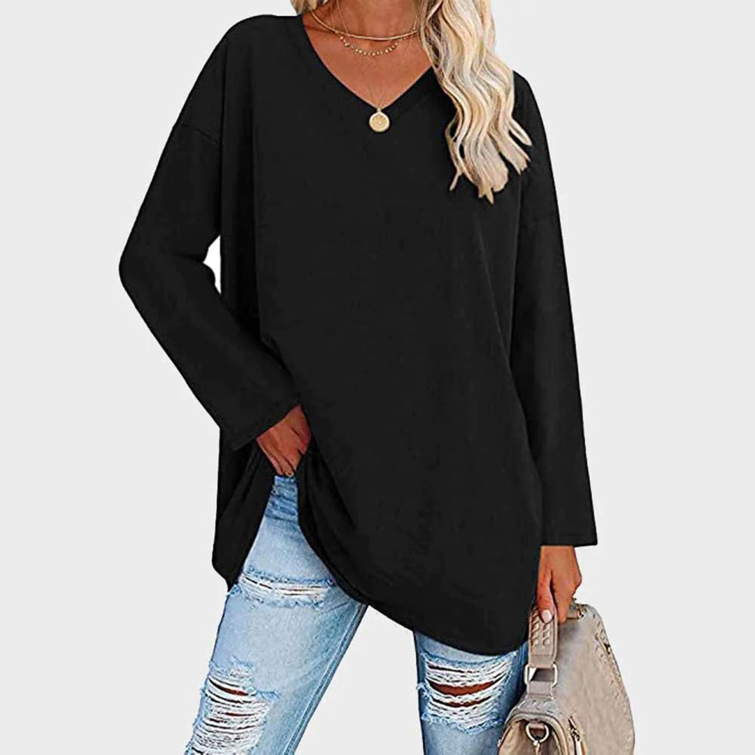 Kvinne i Lightblå genser med V-hals, slitte jeans og beige veske. Perfekt for casual mote og vårantrekk. Trendy og komfortabel stil.